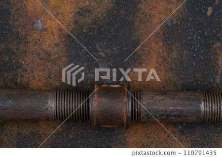 Rusty plumb tube on rusty metal wall Rusty plumb tube on rusty metal wall 110791435