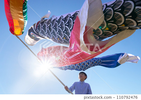 Carp streamers and elementary school boy dancing in the blue sky Carp streamers and elementary school boy dancing in the blue sky 110792476