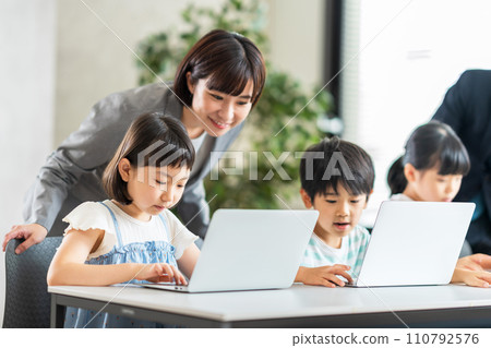 Elementary school students and teachers learning programming. 110792576