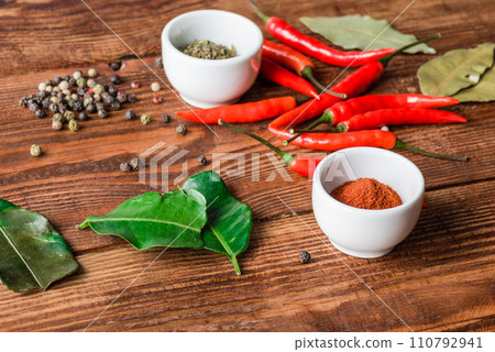 Different condiment in bowls or scattered on kitchen table. Different condiment in bowls or scattered on kitchen table. 110792941