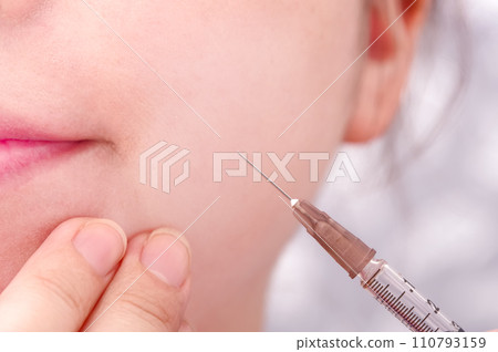 A woman receiving an injection in her mouth A woman receiving an injection in her mouth 110793159