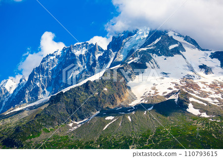 Snowy peak and green slopes of Aiguille Verte mountain, French Alps 110793615