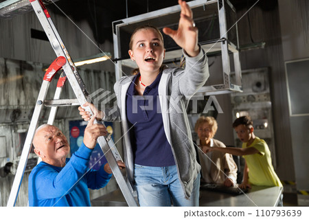 Girl pointing to something while trying to find solution of conundrum with relatives in quest room 110793639