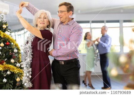 Positive middle-aged man dancing playful Latin dance bachata with mature female partner during celebration Christmas and New Year in choreography studio Positive middle-aged man dancing playful Latin dance bachata with mature female partner during celebration Christmas and New Year in choreography studio 110793689