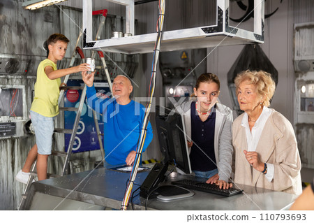 Positively minded family together solve puzzles in a quest room in form of an abandoned laboratory Positively minded family together solve puzzles in a quest room in form of an abandoned laboratory 110793693