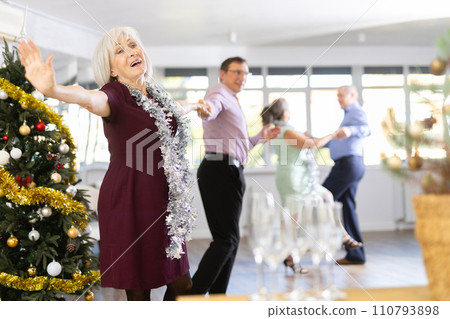 Smiling adult lady in elegant clothes dancing in couple latin dance, energetic and fast jive in dance salon during celebration Christmas and New Year 110793898