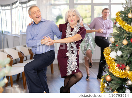Happy caucasian adult man and lady dancing rock and roll dance in dance studio during celebration Christmas and New Year 110793914