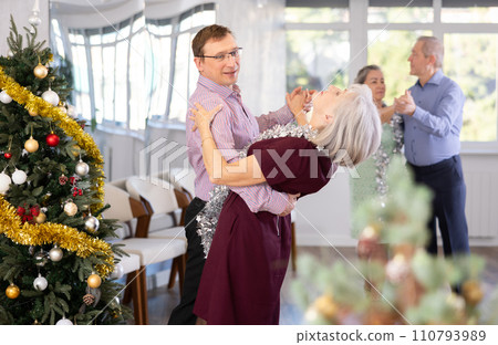 Aged couple during celebration Christmas and New Year dancing cha-cha-cha dance at ballroom Aged couple during celebration Christmas and New Year dancing cha-cha-cha dance at ballroom 110793989