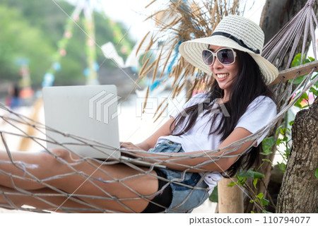 Lifestyle freelance woman using laptop working and relax on the beach. Lifestyle freelance woman using laptop working and relax on the beach. 110794077