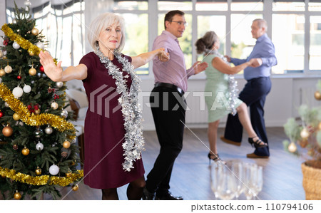 Smiling adult lady in elegant clothes dancing in couple latin dance, energetic and fast jive in dance salon during celebration Christmas and New Year 110794106