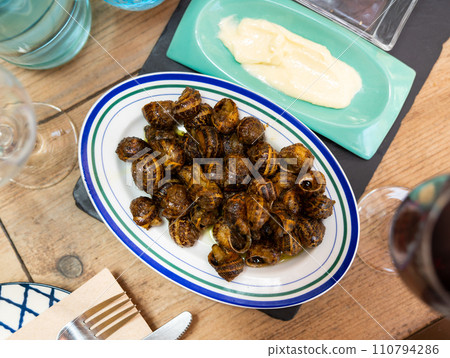 Cooked in shells land snails served on plate with aioli Cooked in shells land snails served on plate with aioli 110794286
