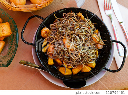 Spainsh dish seafood fried baby eels and prawns with potatoes 110794461