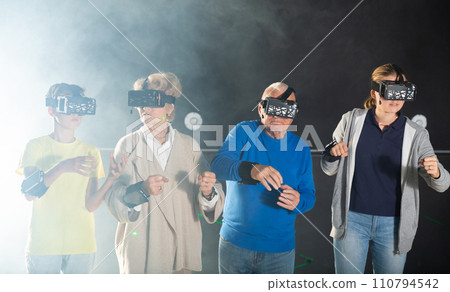Grandparents and grandkids playing VR games together Grandparents and grandkids playing VR games together 110794542