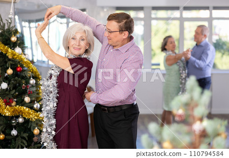 Middle-aged man and elderly woman dancing contemporary discofox in couple in New Year atmosphere 110794584