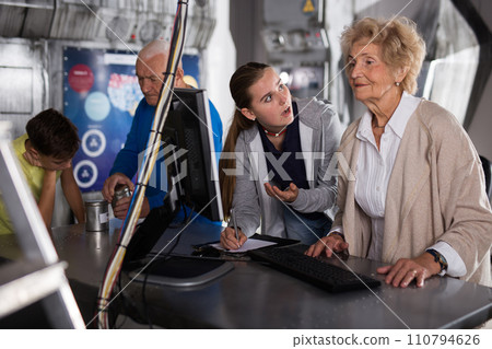 Girl and an elderly grandmother are trying to solve puzzle using computer to get out of quest during corporate event 110794626