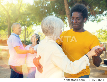 Elderly woman enjoying dance with partner in garden 110794641