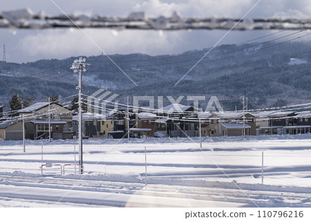Snowy countryside view through electric wires Snowy countryside view through electric wires 110796216