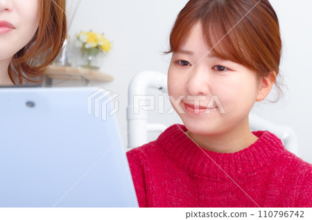 A woman undergoing examination in a dentist's examination room 110796742