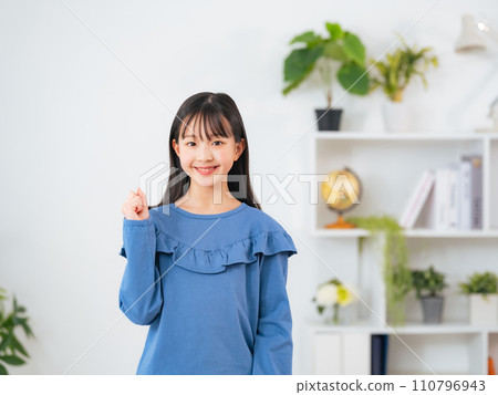 Girl fist pumping in the room 110796943