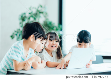 Elementary school students working together on computers. 110797234