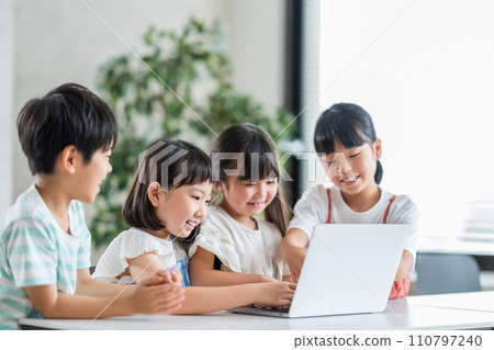 Elementary school students working together on computers. 110797240