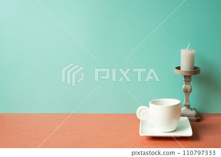 White coffee cup with candle on red table. mint green wall background 110797333