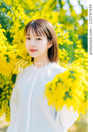 Young woman surrounded by mimosa 110797844