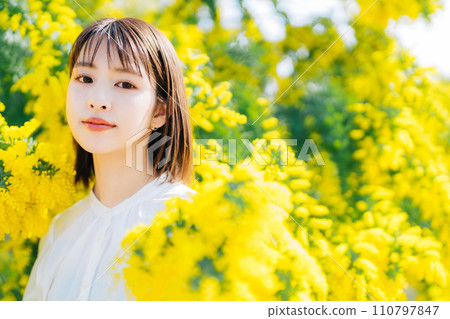 Young woman surrounded by mimosa Young woman surrounded by mimosa 110797847