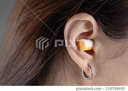 Earplugs for sleeping. Girl's ears close up Earplugs for sleeping. Girl's ears close up 110798495