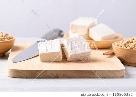 Fresh tofu on cutting wooden board, Vegan food ingredient in Asian cuisine, Plant based diet Fresh tofu on cutting wooden board, Vegan food ingredient in Asian cuisine, Plant based diet 110800385