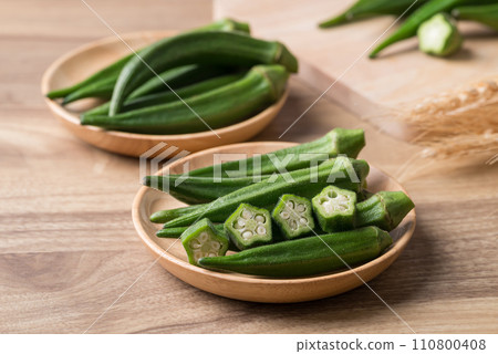 Green okra in wooden bowl prepare for cooking, Organic vegetables Green okra in wooden bowl prepare for cooking, Organic vegetables 110800408