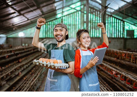 worker couple raise both hands carrying egg tray and pad 110801252