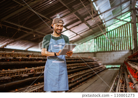Asian entrepreneur working with a pad standing in chicken cage Asian entrepreneur working with a pad standing in chicken cage 110801273