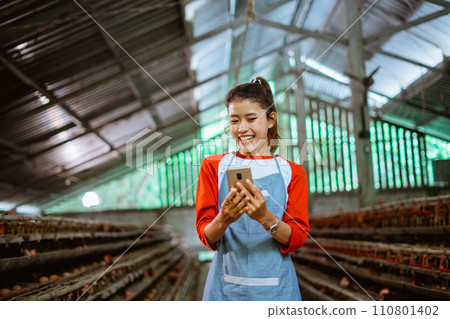 Asian female entrepreneur happily laughs while looking at cell phones 110801402