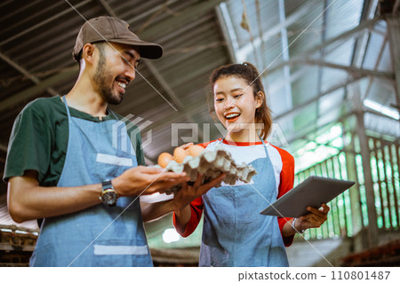 Female worker using a pad and male worker carrying tray Female worker using a pad and male worker carrying tray 110801487