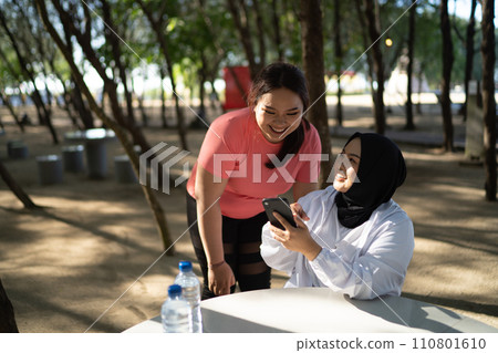 asian women in sportswear taking break after exercise 110801610