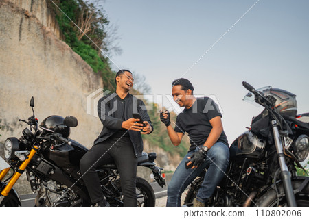 happy indonesian rider holding phone laughing happy indonesian rider holding phone laughing 110802006