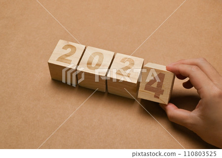 Businessman flipping wooden block cube to 2024. Starting to new year and financial plan concept 110803525