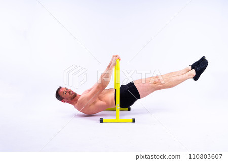 Male gymnast performing handstand on parallel bars, studio shot 110803607