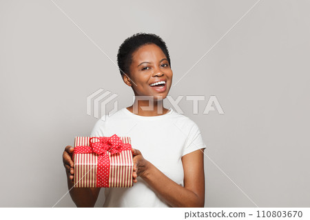Excited happy young woman with gift present box standing on white background 110803670