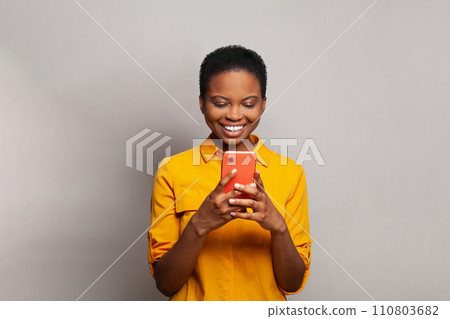 Beautiful young woman texting on her phone. Happy casual model student using smartphone Beautiful young woman texting on her phone. Happy casual model student using smartphone 110803682