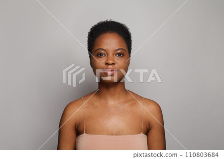 Gorgeous healthy african american woman with clear fresh dark skin posing on gray background Gorgeous healthy african american woman with clear fresh dark skin posing on gray background 110803684