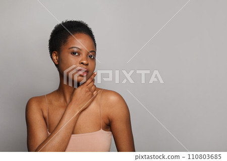Positive healthy african american woman with clear fresh dark skin posing on gray background Positive healthy african american woman with clear fresh dark skin posing on gray background 110803685