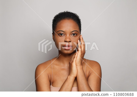 Elegant healthy african american woman with clear fresh dark skin posing on gray background 110803688