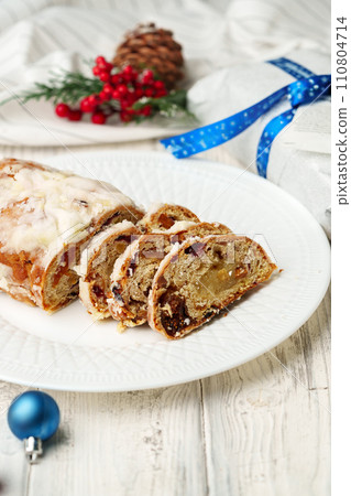 Christmas stollen on plate on white wooden table Christmas stollen on plate on white wooden table 110804714