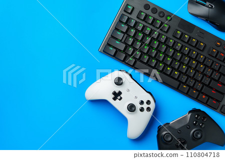Computer keyboard and joystick on blue background top view 110804718