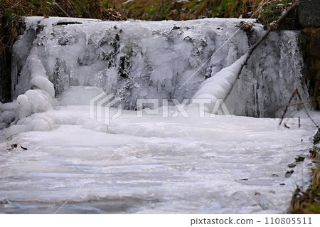 Frozen stream. Beautiful winter nature background. Frost, ice and snow in the winter. 110805511