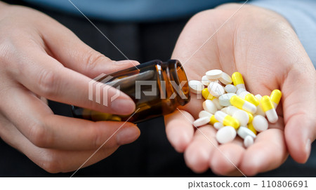 Pours out from bottle pills into palm, taking medication and nutritional supplements. Medicine for my headache. 110806691