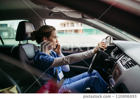Female nurse going home from work, getting into car. Female doctor driving car to work, on-call duty, phone calling. Work-life balance of healthcare worker. Female nurse going home from work, getting into car. Female doctor driving car to work, on-call duty, phone calling. Work-life balance of healthcare worker. 110806893