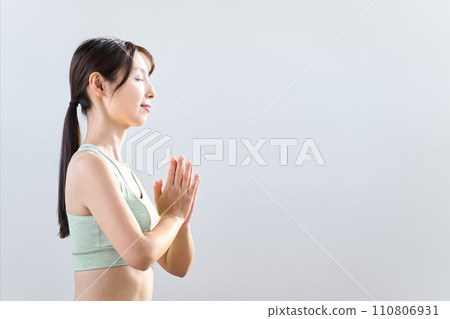 A woman meditating with her eyes closed 110806931